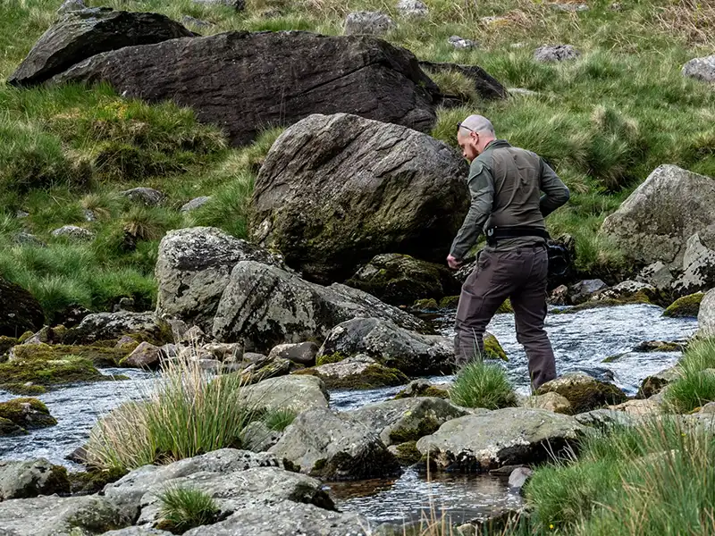 Man looking for gold near a stream